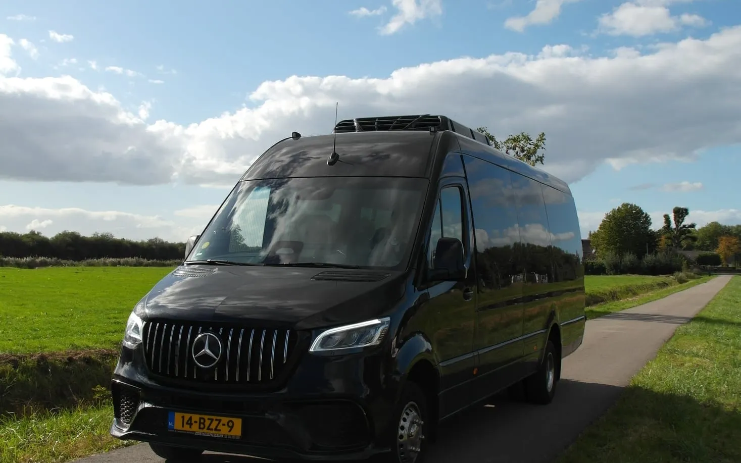 Een minibus van Van Asselt op een landweg in het Groene Hart